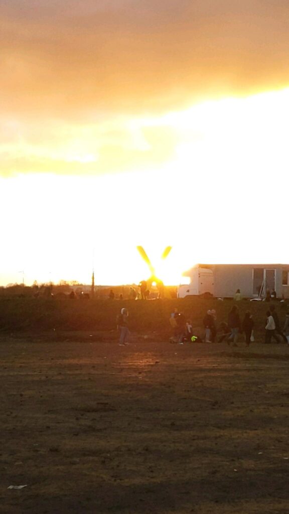 The sun sets in Lützerath behind one of the yellow Xes.