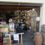 Ein Blick in die erste Garage des Umsonstladens. Die Regale sind voll gefüllt mit vielen verschiedenen Waren.